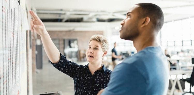 colleagues discussing whiteboard content