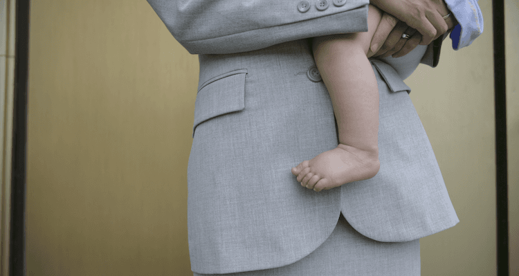 person in a suit holding a baby
