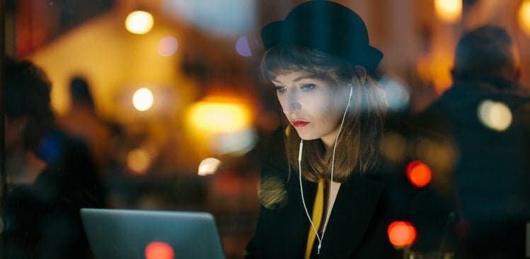 person in a window looking at a laptop